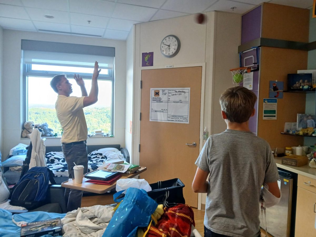 Eli Griffith (right) plays basketball with his dad, Joe Griffith (left), in Eli's hospital room at Mott Children's Hospital.