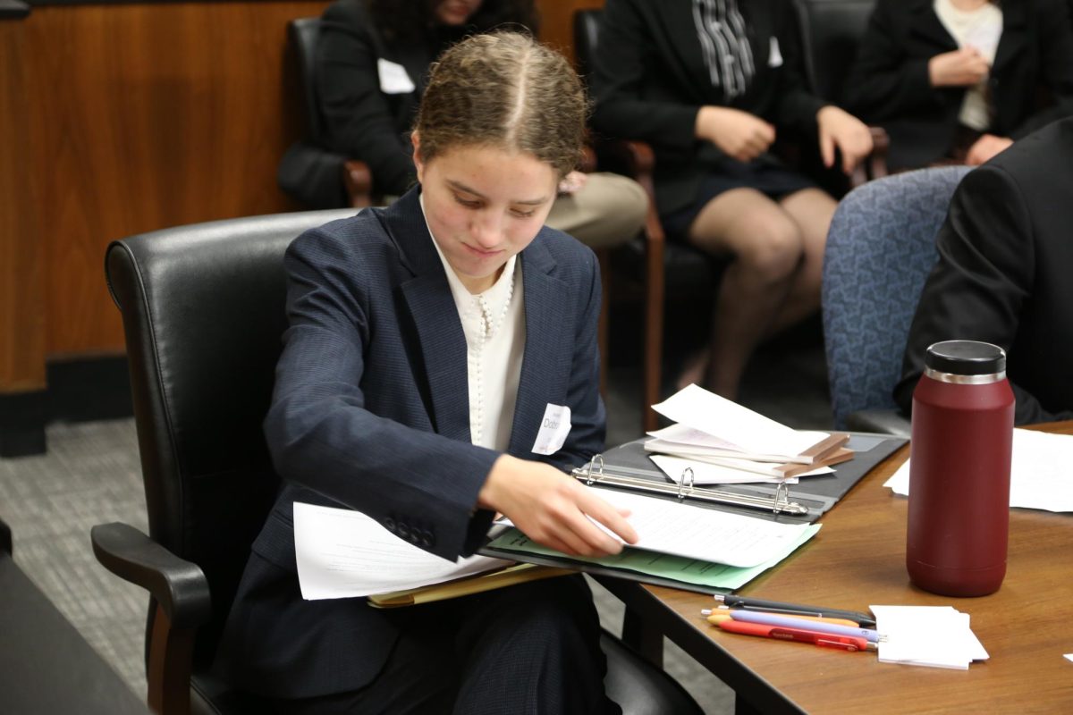 Annette Dobson looks over her papers at counsel table during a trial.