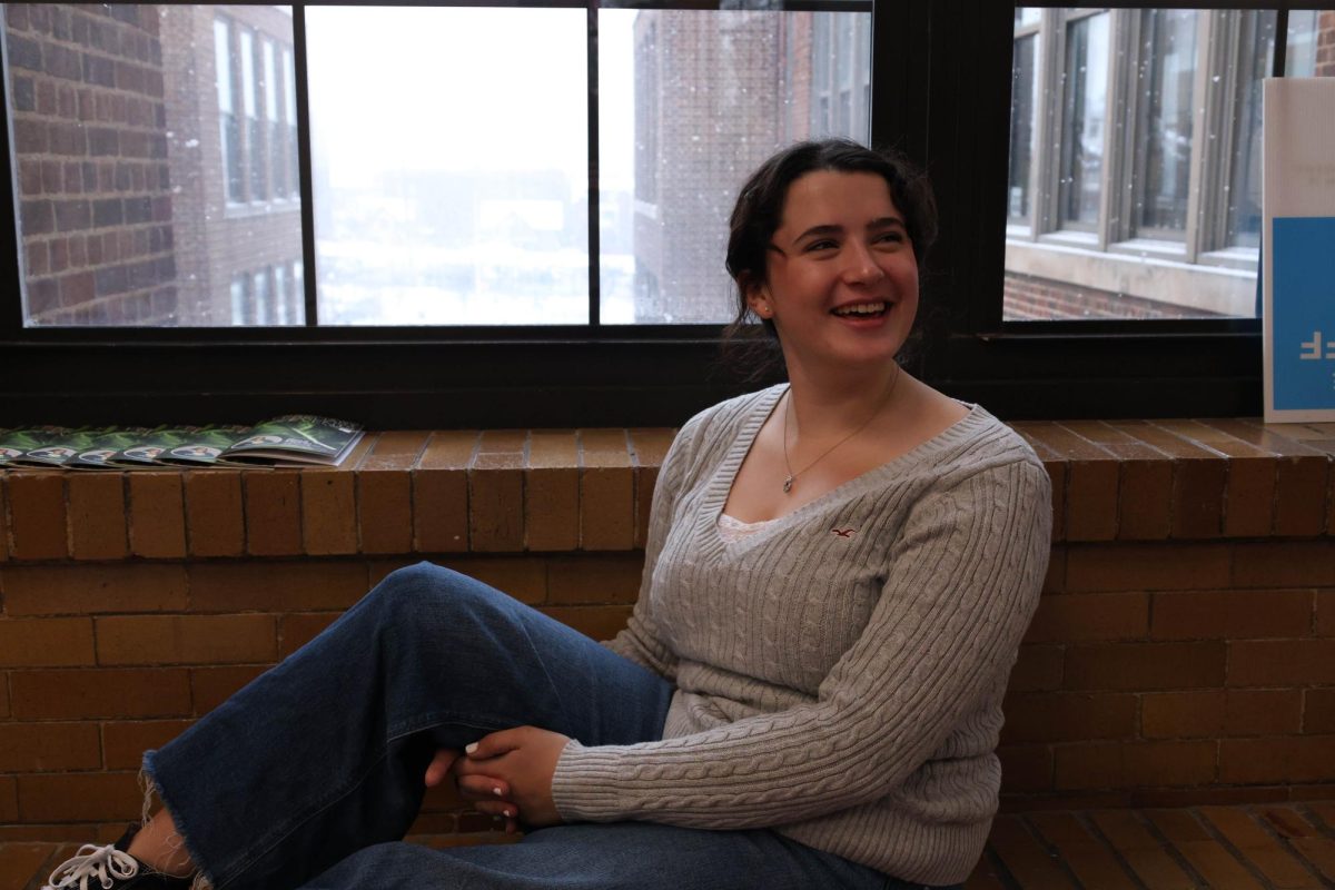 Ellie Fox sits on the third floor ledge, laughing with her friend. She was enjoying taking photos and doing interviews with her group in journalism. "I like having assigned groups in class," Fox said. "It gives me a chance to talk to new people."