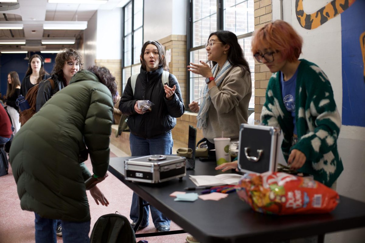 Kaylee Gadepalli and Eva Millwood stand behind a table in the hallway selling candy grams for feminist club to raise money for the Immigrants Rights Center. They had been raising money for the past couple of days. "This week, people have really been stepping up and being a lot more active," Gadepalli said. "We thought the best way that feminist club could contribute was by bringing back our annual candy gram fundraiser, but instead of keeping it to ourselves, donating it to a good cause."