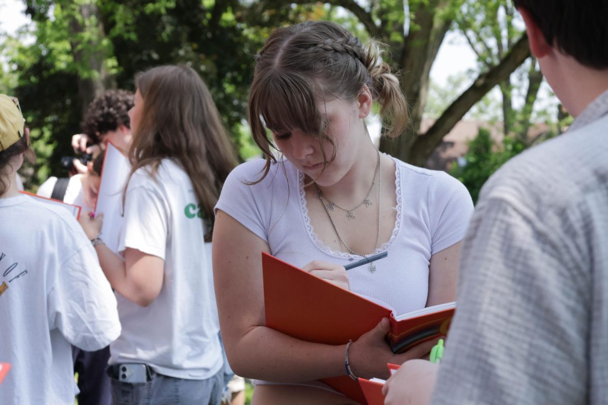 CHS junior Rosie Matish writes a thoughtful message in a friends year book. 